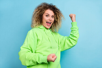 Fototapeta premium Photo of champion triumphant lady celebrate win wear green sweatshirt isolated blue color background