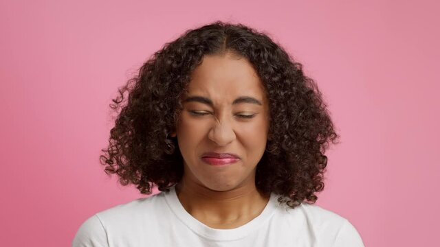 Portrait Of Black Woman Smelling Disgusting Smell Over Pink Background