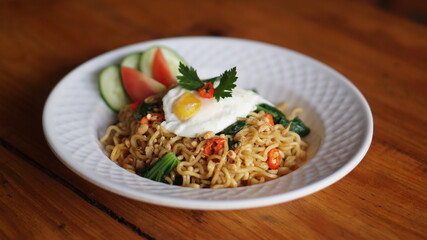 A plate of fried noodles with sunny side up eggs