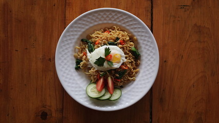A plate of fried noodles with sunny side up eggs