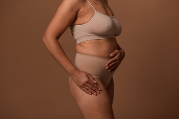 Body positive concept. Studio shot of an imperfect body of a plump woman with stretch marks on her...