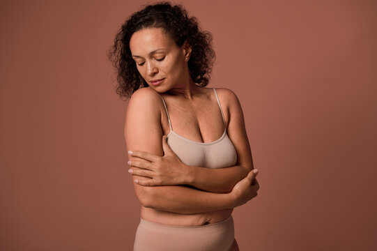 Dark-haired curly woman with imperfect body, cellulite and stretch marks  wearing beige underwear, smiles hiding her face posing against colored  background with copy space. Body positivity concept 27046218 Stock Photo at  Vecteezy