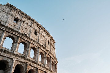 Colosseum in Rome in summer days with a bird flying over.