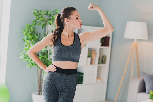 Photo of confident cool lady wear sport outfit kissing arm muscles indoors home house