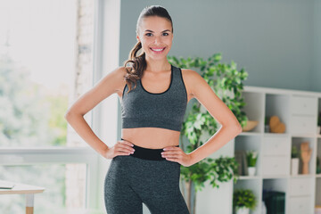 Photo of strong confident lady wear sport outfit hands arms waist smiling indoors home house
