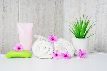 Fototapeta na wymiar Toothbrushes, soap and two towels. Rose flowers aromatherapy home