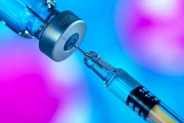 The syringe with the needle taking up the contents of the ampoule. Vaccination concept. 