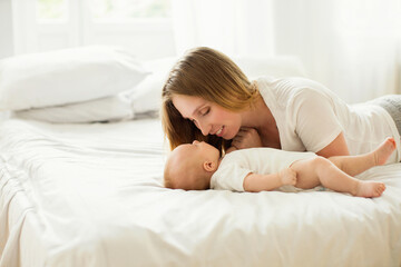 Happy young mother with her newborn baby at home.