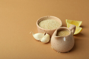 Concept of tasty food with tahini sauce on beige background