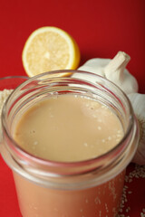 Concept of tasty food with tahini sauce on red background
