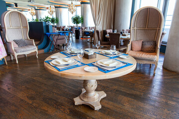 Round dining table for four. Interior of cozy luxury restaurant with original design