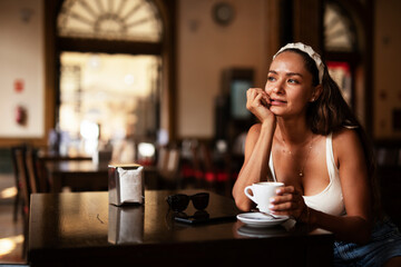 Stylish young woman drinking coffee at cafe. Beautiful girl enjoy in fresh coffee