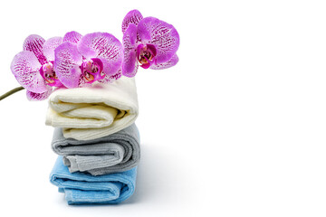 Orchid flower and towels on white isolated background. Spa, relaxation concept