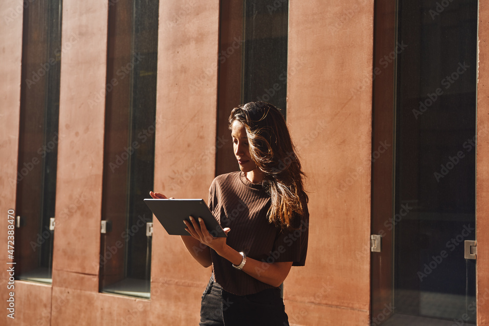 Wall mural busy young businesswoman standing on street