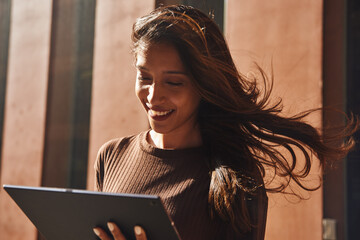 Smiling businesswoman with tablet on street