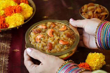 Sakkarai pongal Indian festival food woman hand serving traditional popular mithai sweet pongal dessert made on the festival day of Pongal Makar Sankranti vishu Diwali India.