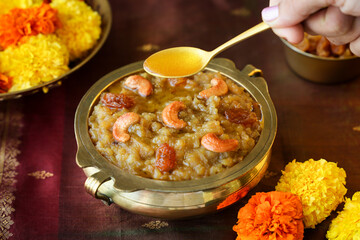 Sakkarai pongal Indian festival food woman hand serving pouring ghee on sweet pongal traditional...