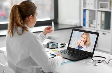 healthcare, technology and medicine concept - female doctor with laptop computer and drug having video call with ill patient at hospital