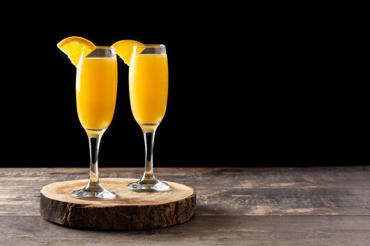 Orange mimosa cocktail on wooden table. Copy space