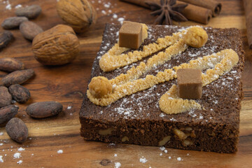 délicieux brownie au gâteau au chocolat avec noix, bâtons de cannelle et fèves de cacao sur planche de bois