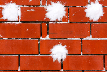 Brick wall with four snowballs on it.