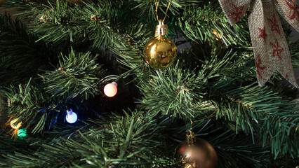 Obraz na płótnie Canvas round golden toy on the Christmas tree weighs