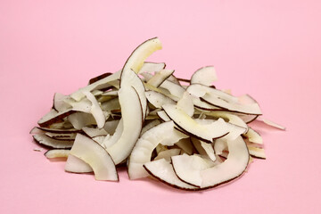 pile of coconut chips on a pink background