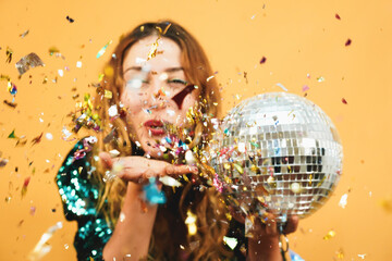 Blurred happy girl blowing confetti holding vintage disco ball - Defocused photo - obrazy, fototapety, plakaty