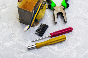 pliers electric transformer and screwdrivers on the table surface