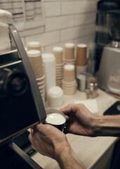 the hands of the barista in the process of making coffee