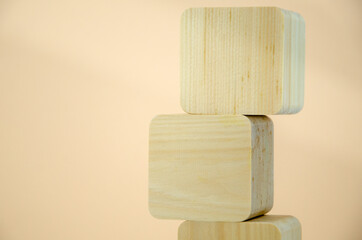 empty wooden cubes are stacked in a tower shape, one on top of other. blocks are vertically lined on beige background. concept of business, interaction, growth. Template for design, space for text