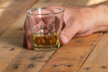 Hand holding a small glass liquor.