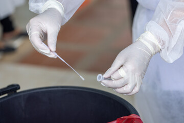 The doctor with PPE suit, Doctor is using a test coronavirus(covid-19) with the use of an ATK test kit by nasal swab.
