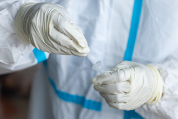 The doctor with PPE suit, Doctor is using a test coronavirus(covid-19) with the use of an ATK test...