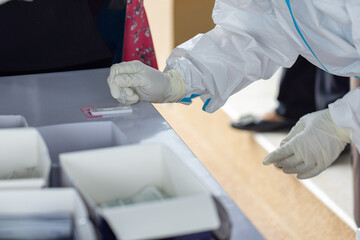 The doctor with PPE suit, Doctor is using a test coronavirus(covid-19) with the use of an ATK test...