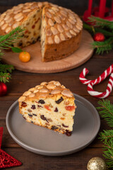 Traditional Christmas Dundee cake with dried fruits and almonds on a wooden board. Festive dessert. Rustic style, selective focus