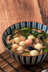 Red and white tangyuan with savory soup.