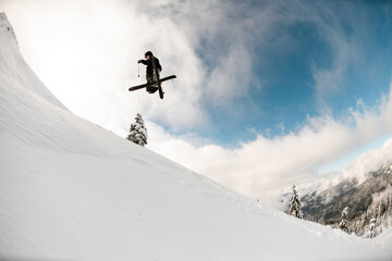 Great view of snowy mountain slope and skier jumping air