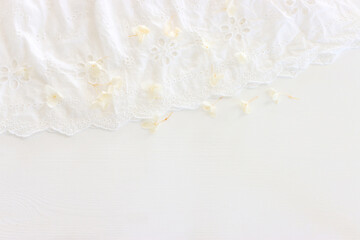 Background of white embroidered delicate lace fabric and dry flowers