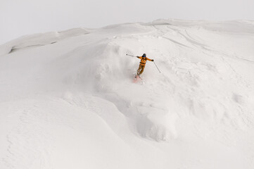 Naklejka na ściany i meble Active freeride skier rides on powder snow down the slope