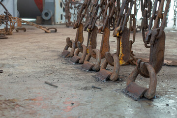 Safe cargo lashing onboard of ship deck with cargo lashing chains and tensioner.