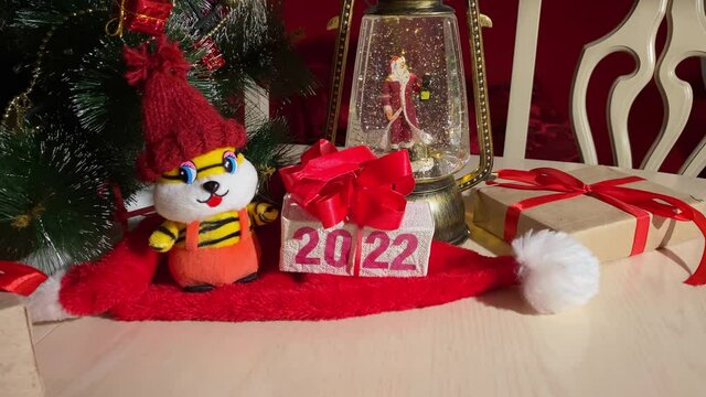 Tiger symbol of 2022 new year, Christmas lantern with Santa Claus at New Year tree with decoration. Holiday celebration concept. 