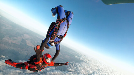 Two skydivers jumps from the aircraft in a star position
