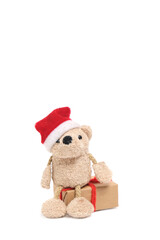 Little cute soft bear in Santa Claus hat is sitting on gift box.Isolate on white background.