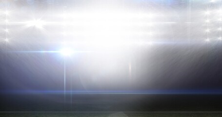 Illuminated american football stadium with glowing bright lights at night