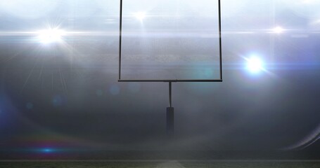 Empty goal post against illuminated bright american football sports field at night