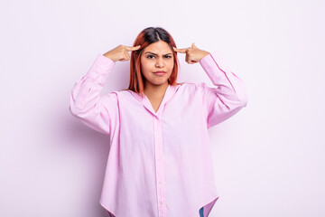young hispanic woman with a serious and concentrated look, brainstorming and thinking about a...