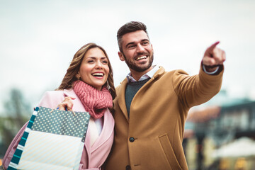 Portrait of happy couple with shopping bags.