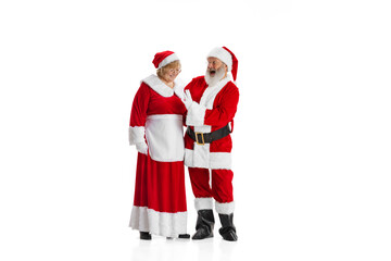 Emotional senior man and woman, Santa Claus and his wife in traditional costume isolated on white background. Christmas, New Year 2022