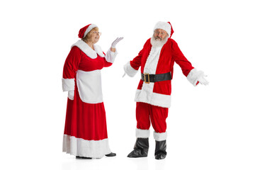 Two people, elder man and woman, Santa Claus and missis Claus in traditional New Year costume talking isolated on white background.